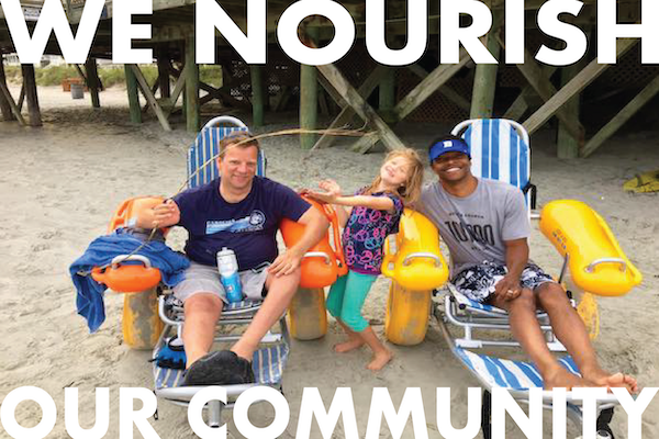 two guys in beach wheelchairs and one girl smiling